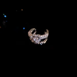 Close-up of elegant swan zircon ear cuff without piercing on black background