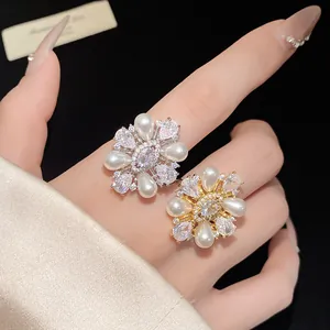 Détail d'une bague ouverte fleur plaquée or 14k avec perles et zircons cubiques