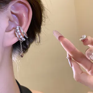Close-up detail of elegant silver ear cuff featuring pearls and heart charms on ear