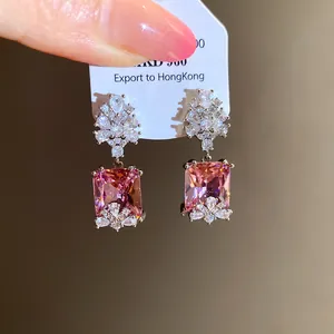 Detailed macro view of vintage-style pink rectangular zircon drop earrings with clear gems