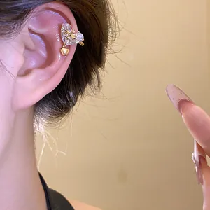 Detailed view of a glittering heart-shaped zircon ear cuff with a dangling heart charm