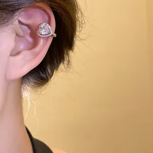 Macro view of elegant heart-shaped zircon ear cuff clip-on earring for women without piercing