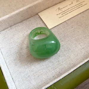 Detailed macro view of a green marbled resin ring with a chunky domed minimalist design