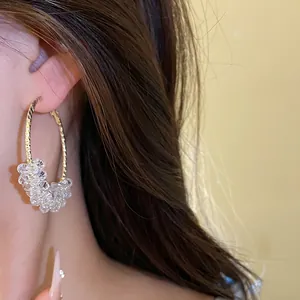 Detailed shot of gold hoop earring with clear crystal beaded cluster design