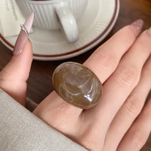 Close-up shot of a vintage style brown marbled resin ring with white swirl patterns
