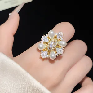 Détail macro d'une bague fleur plaquée or 14k avec perles et zircons brillants