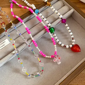Close-up detail of freshwater pearl and colorful bead necklaces with heart and mushroom charms
