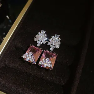 Close-up of vintage palace style earrings with pink square zircon and floral details.