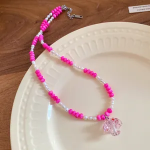 Detailed view of pink beaded necklace with freshwater pearls and mushroom pendant