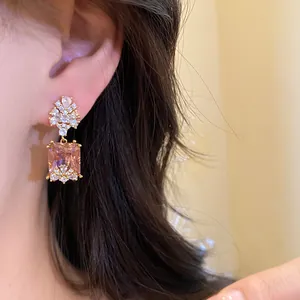 Close-up of vintage square champagne zircon drop earring worn on ear