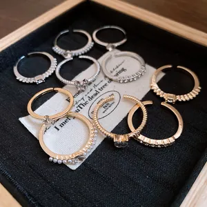 Nahaufnahme eines minimalistischen Ring-Sets mit Strasssteinen und Perlen in Gold und Silber.