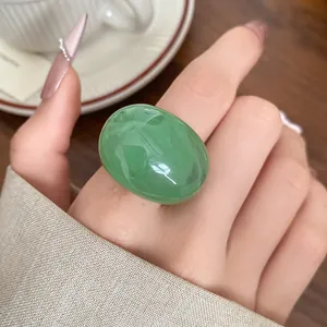 Detailed view of a green marbled resin stone ring featuring a minimalist polished finish