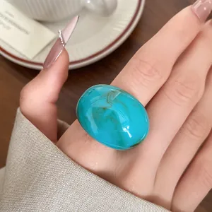 Detail shot of a turquoise marble resin ring on finger