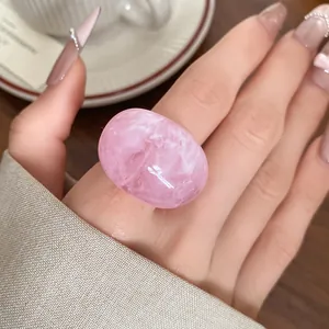 Detail shot of a large pink marbled resin ring featuring unique swirled textures