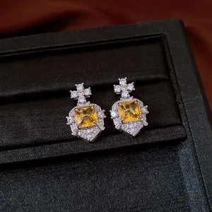 Detailed view of vintage palatial style earrings with square yellow zircon and star accents