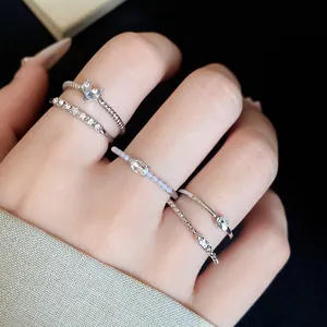 Detailansicht eines 5-teiligen Silberring-Sets mit Strass und Perlen an einer Hand