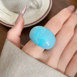 Close-up of a trendy blue marbled resin ring with a glossy high-end finish for stylish women