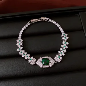 Macro detail view of vintage emerald green square zircon bracelet with floral clusters