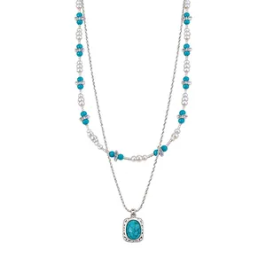 Double-layered necklace with white glass pearls and a rectangular turquoise stone pendant
