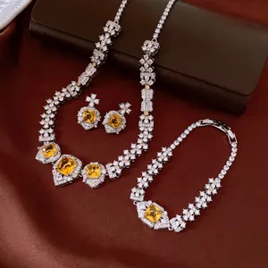 Vintage square yellow zircon necklace bracelet earrings set on brown satin background.