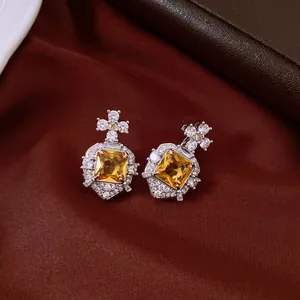 Macro view of vintage palace style earrings with square yellow zircon and clear crystals