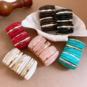 Multi-colored marbled acrylic cuff bracelets with gold accents for elegant styling