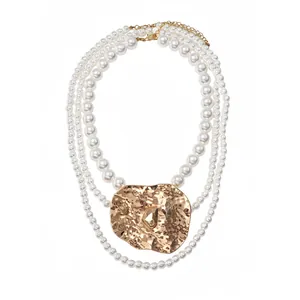 Elegant multi-layer pearl beaded necklace with an irregular hammered gold folded metal pendant