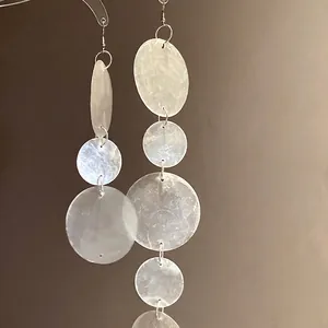 Eleganti orecchini pendenti asimmetrici in conchiglia bianca con finitura in madreperla
