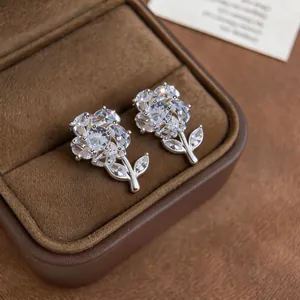 Primo piano dettagliato di orecchini a lobo rosa in zirconia in un portagioie marrone