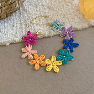 Vista dettagliata di un bracciale di fiori in rafia colorata con design in stile estate.