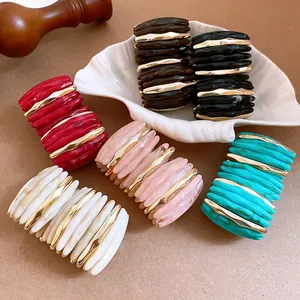 Detailed view of variety marbled acrylic bracelets with gold-tone metal accents.
