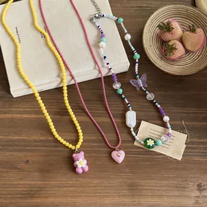 Detailed view of three colorful handmade beaded necklaces with bear and heart charms