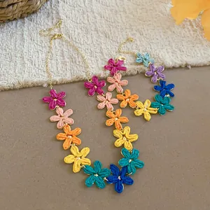 Dettaglio ravvicinato del set di gioielli con collana e braccialetto in fiori di rafia
