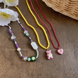 Detail of sweet playful necklaces featuring resin bear, heart, and colorful flower beads