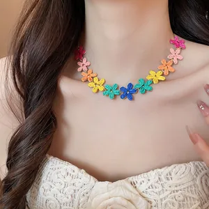 Collana vivace con fiori in raffia colorata in stile dopamina indossata da modella