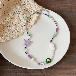Detail view of a colorful stainless steel beaded necklace with resin butterfly