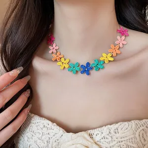 Dettaglio di una vivace collana di fiori in rafia colorata indossata da una modella.