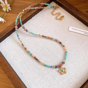 Detailed view of bohemian colorful beaded necklace with gold flower pendant