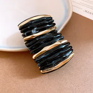 Detail of acrylic marbled spliced bracelet with elegant black and gold wavy texture.