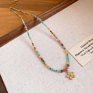 Detailed shot of multi-colored beaded necklace with gold daisy charm