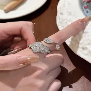 Close-up of elegant leaf-shaped ring with pavé zircons and dangling teardrop stone