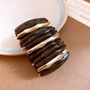 Detailed view of dark brown marbled acrylic segments paired with gold-tone accents
