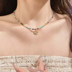 Detail view of colorful Bohemian beaded necklace with golden flower pendant on neck