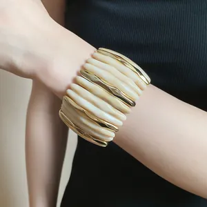 Detailed close-up of chunky acrylic marbled and gold-tone segmented cuff bracelet