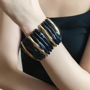 Elegant chunky acrylic marbled cuff bracelet with gold metal accents worn on female wrist