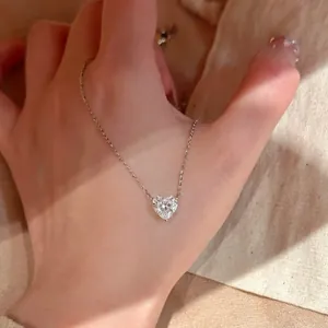 Elegante silberfarbene Halskette mit herzförmigem Zirkonia-Anhänger, auf der Hand gezeigt