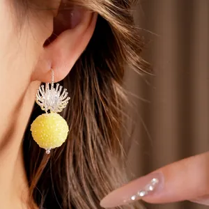 Elegant minimalist floral glass drop earrings with a textured yellow round bead