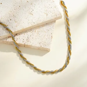 Gros plan sur le collier en chaîne à chevrons torsadée en acier doré et argenté