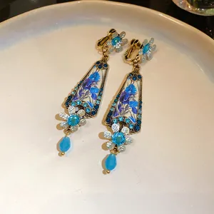 Detailed view of vintage blue floral earrings with rhinestone borders and flower pendants