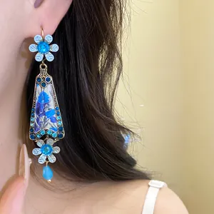 Close-up detail of vintage style blue resin flower drop earrings featuring sparkling rhinestones